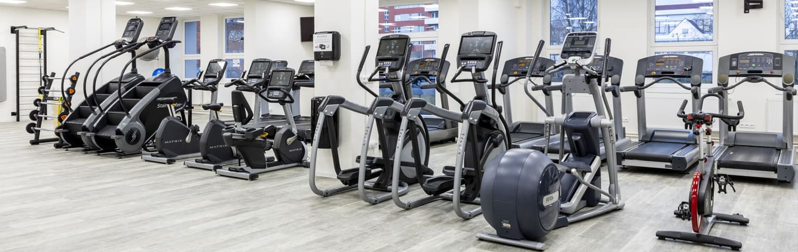 Kardio zóna v přízemí: běhací pásy, eliptické trenažéry a Stairmastery u prosklené stěny